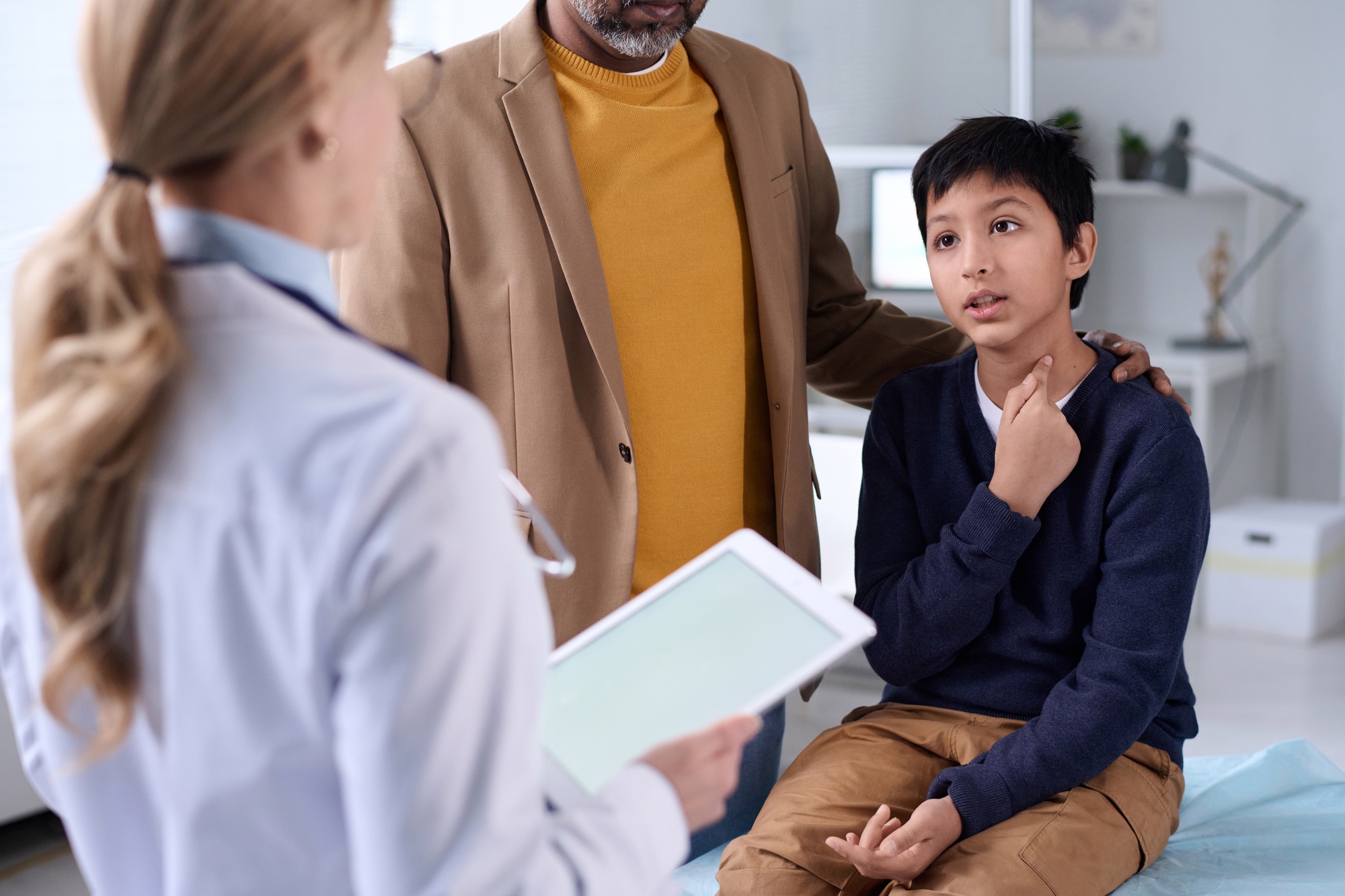 Boy Explaining Sore Throat to Doctor
