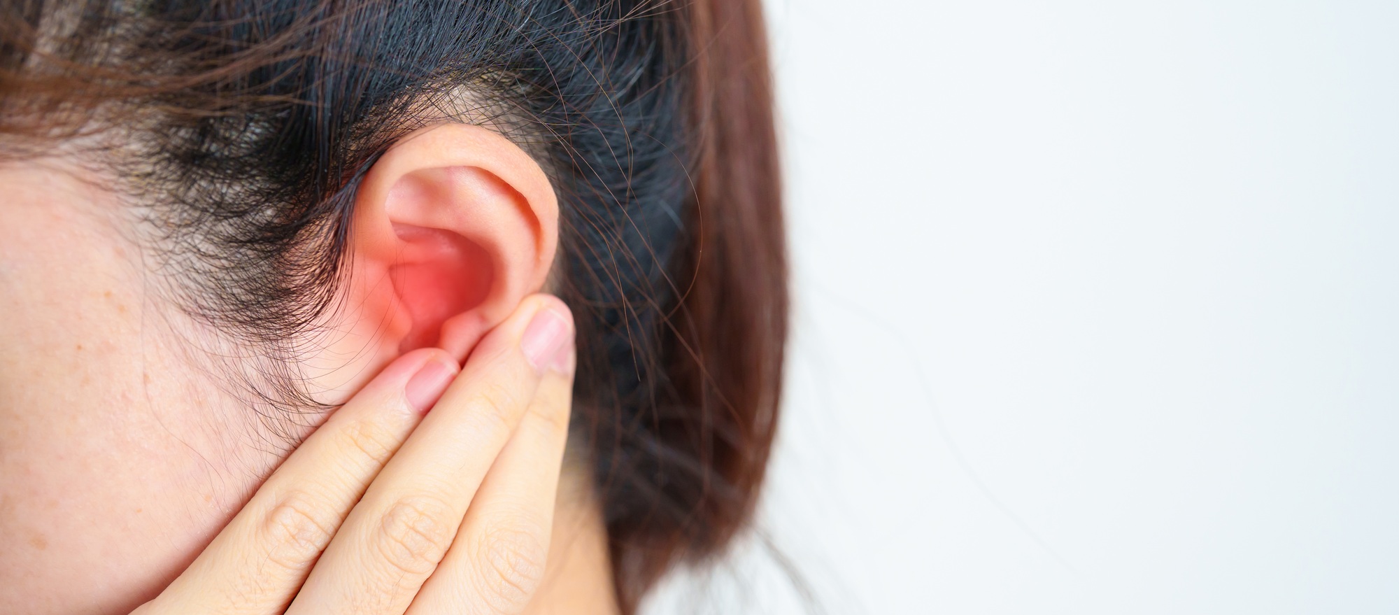 Woman holding her painful Ear. Ear disease, Atresia